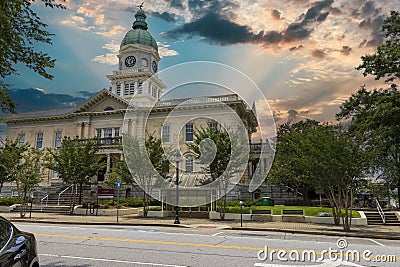 A gorgeous summer landscape at Athens City Hall with a clock tower with a blue dome on top with lush green trees, plants and grass Editorial Stock Photo