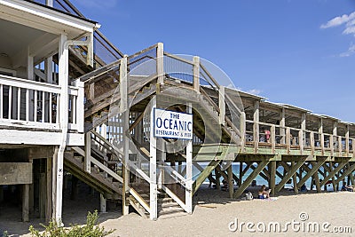 A gorgeous summer landscape at Crystal Pier with a sandy beach, blue ocean water, people relaxing, lush green plants and grass Editorial Stock Photo