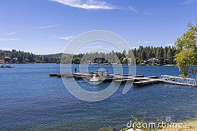 A gorgeous summer landscape at Lake Arrowhead with a family standing on the back of a boat surrounded by blue water Editorial Stock Photo