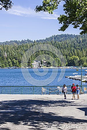 A gorgeous summer landscape at Lake Arrowhead village with boats and yachts sailing on the rippling blue later water, homes Editorial Stock Photo