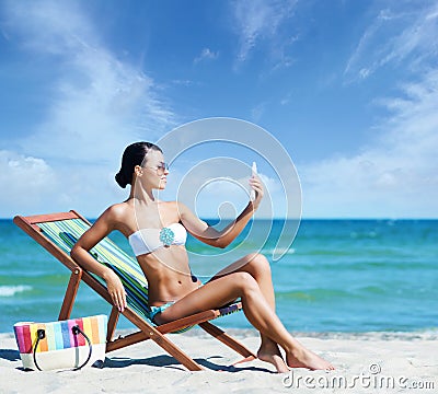 Gorgeous young girl with a suntan cream on the beach Stock Photo