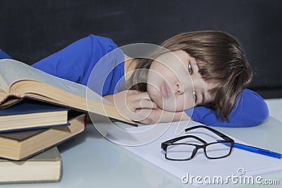 Gorgeous young hardworking student tired among his books while studying Stock Photo