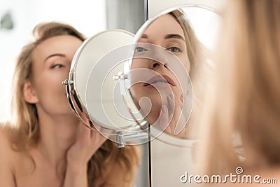 Gorgeous young naked woman looking at mirror. Stock Photo