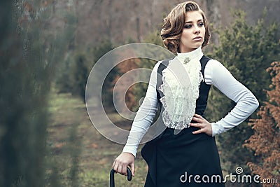 Gorgeous young woman with elegant Victorian hairstyle walking in the misty autumn park Stock Photo
