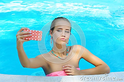 Gorgeous young woman taking photo of herself in the pool Stock Photo