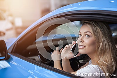 Beautiful young woman buying new car at the dealership Stock Photo