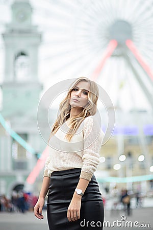Gorgeus blonde woman in leather skirt posing on the ferris wheel background Stock Photo