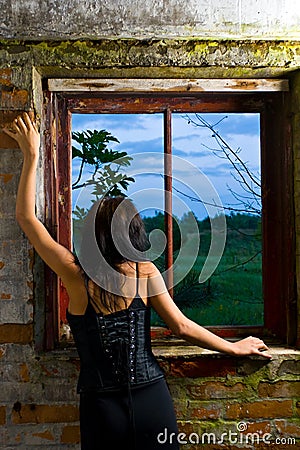 Goth girl looking out window Stock Photo