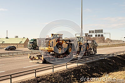 Volvo wheel loaders being transported on a trailer.. Editorial Stock Photo