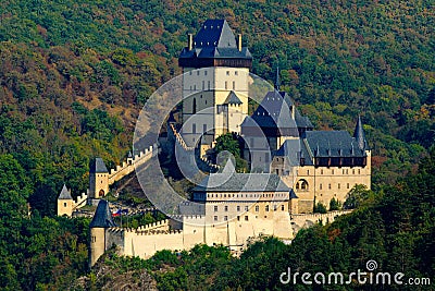 Gothic royal castle Karlstejn in green forest during autumn, Central Bohemia, Czech republic, Europe. State caste in the forest. Stock Photo