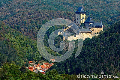 Gothic royal castle Karlstejn in green forest during autumn, Central Bohemia, Czech republic, Europe. State caste in with village Stock Photo