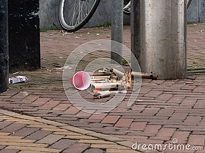 Gouda, South Holland/The Netherlands - January 1 2020: a plastic cup empty sigarette box and trash from the fireworks on the Editorial Stock Photo