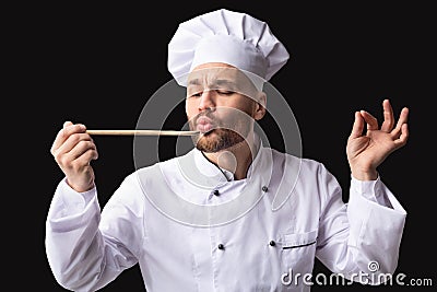 Gourmet Chef Tasting Dish Approving Taste Posing Over Black Background Stock Photo