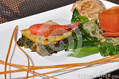 Gourmet design food. Shrimp on a savoury cake with greens Stock Photo