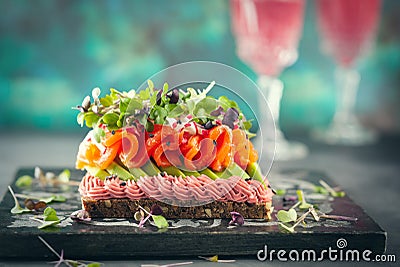 Gourmet sandwich with smoked salmon,avocado, beet hummus and sprouts Stock Photo
