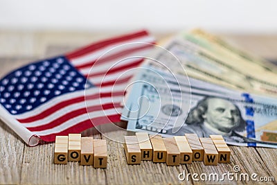 Government Shutdown USA concept with American flag and money bills on white background and wooden board Stock Photo