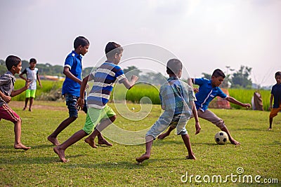 Children playing football on the field. School going kids playing soccer game to compete and win school league Editorial Stock Photo