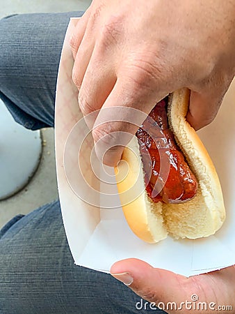 Man grabbing street food bratwurst Stock Photo