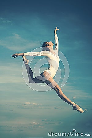 Grace in every move. Practicing art of classical ballet. Ballerina jumping on blue sky. Cute ballet dancer. Pretty woman Stock Photo