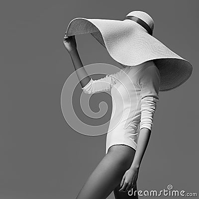 A graceful woman posing with a large wide-brimmed hat. Stock Photo