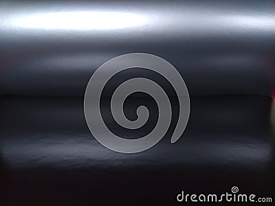 Gradient on a gray-black background. Horizontally folded shiny paper or foil with overflow and highlights. Mysterious radiance. Stock Photo