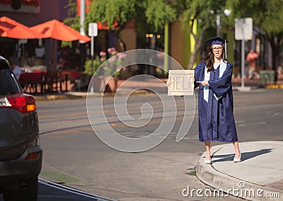 Graduate Pointing to Help Sign Stock Photo