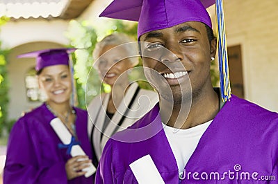 Graduate Student With Family In Background On Convocation Day Stock Photo