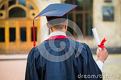 Graduate student hands holding diploma from the back Stock Photo