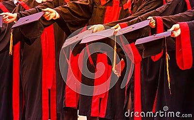 Graduate Students hold hats in hands in university graduation success ceremony. Congratulation on Education Success, Graduation Stock Photo