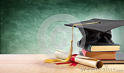 Graduation Cap And Diploma On Table Stock Photo