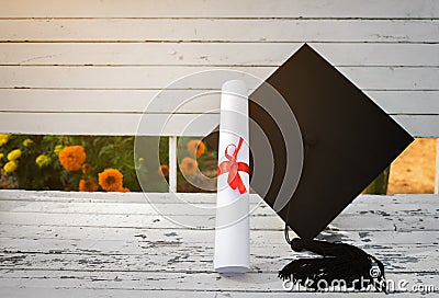 Graduation cap, Hat with degree paper on white wood table, abstract light background Empty ready for your product display or mont Stock Photo