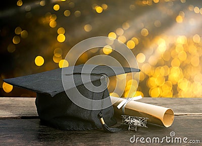 graduation cap, hat with degree paper on wood table, abstract li Stock Photo