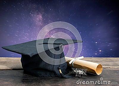 graduation cap, hat with degree paper on wood table, milky way b Stock Photo