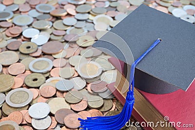 Graduation cap and textbook on many stacked coins cash - Scholarship, money saving or loan for education concept. Stock Photo