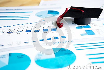 A graduation caps on blue graphs and charts printed Stock Photo