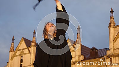 Graduation - girl throws her hat in the air and smiles to camera Stock Photo