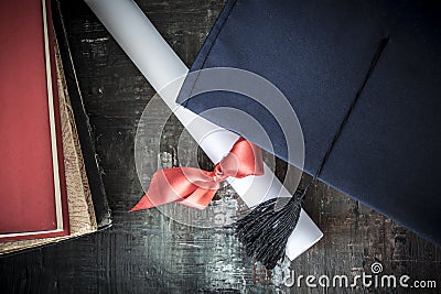 Graduation hat and diploma on table Stock Photo