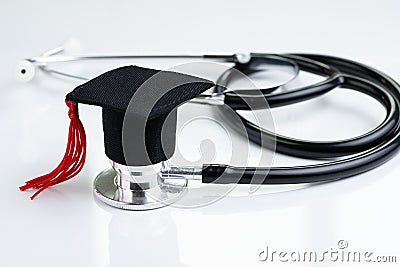 Graduation hat on doctor stethoscope, white background using as medical school, health care education or doctor`s university Stock Photo