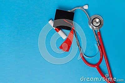 graduation medical concetp. Graduation cap, diploma and stethoscope on blue background Stock Photo