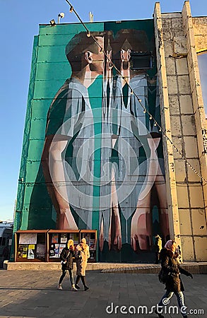 Graffiti in the form of a person entering through the looking glass Editorial Stock Photo