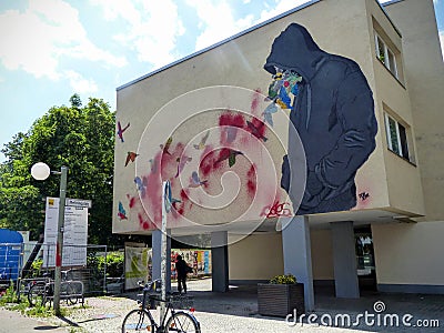 Graffiti of a building with a boy and hummingbird to Berlin in Germany. Editorial Stock Photo