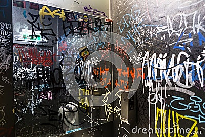 Graffiti vandalism tag writing indoor WC toilet restroom wall text color Stock Photo