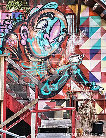 Grafitti of colorful figure drinking coffee in Auckland. Editorial Stock Photo