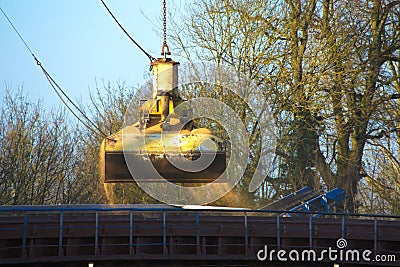 Crane bucket unloading ship. Stock Photo