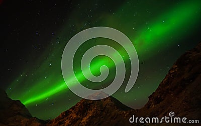 Grain and noise bright glow green northern aurora lights in clear sky at night in Lofoten Islands, Norway Stock Photo