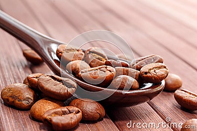 Grains of coffee close-up. Coffee beans are located on a spoon a Stock Photo