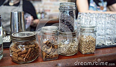 Grains and spices for whiskey cocktails on display in jars at a distillery Editorial Stock Photo