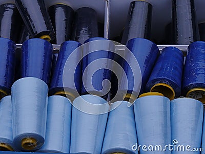 Gran rolls, partly covered with dust, in shades from light blue to dark blue, stored in a plastic box. raw material for handicraft Stock Photo