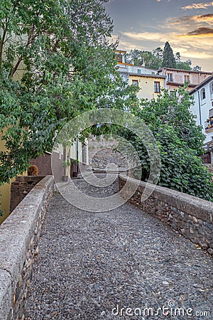 Granada empty narrow streets around Carrera Del Darro. Narrow cobbled streets of Granada in sunshine and blue sky above. Stock Photo