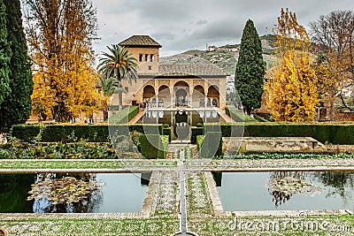 Granada, Spain - November 25, 2018. Generalife gardens near Alhambra complex.Pool framed by flowerbeds, fountains, colonnades and Editorial Stock Photo